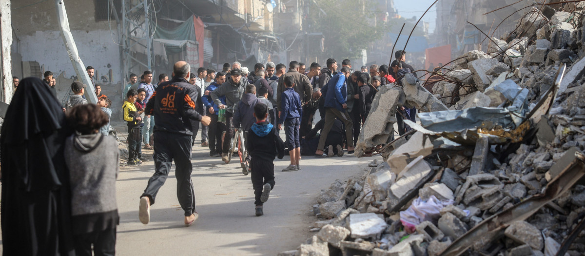 La gente acude en ayuda de un hombre herido en un ataque israelí contra el campo de refugiados de Bureij, en el centro de la Franja de Gaza,