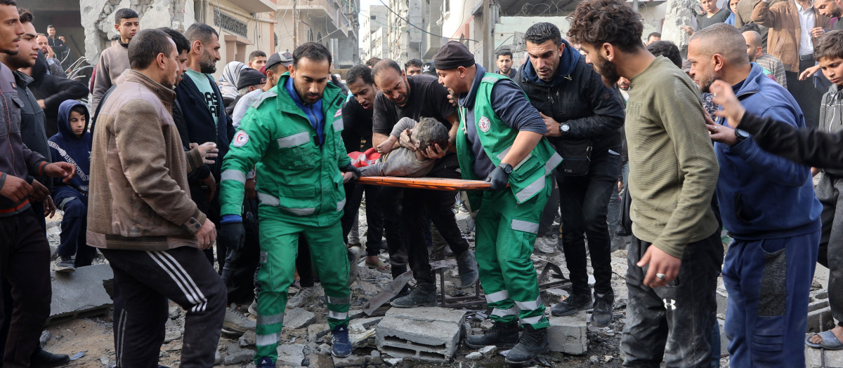 Los rescatistas evacuan a un niño herido en el lugar de un ataque israelí en una zona residencial del barrio de Tuffah, al este de la ciudad de Gaza,