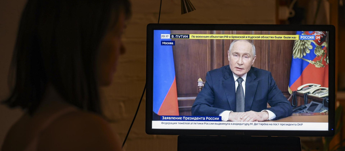 Una persona observa el discurso televisado del presidente ruso, Vladimir Putin, en Moscú