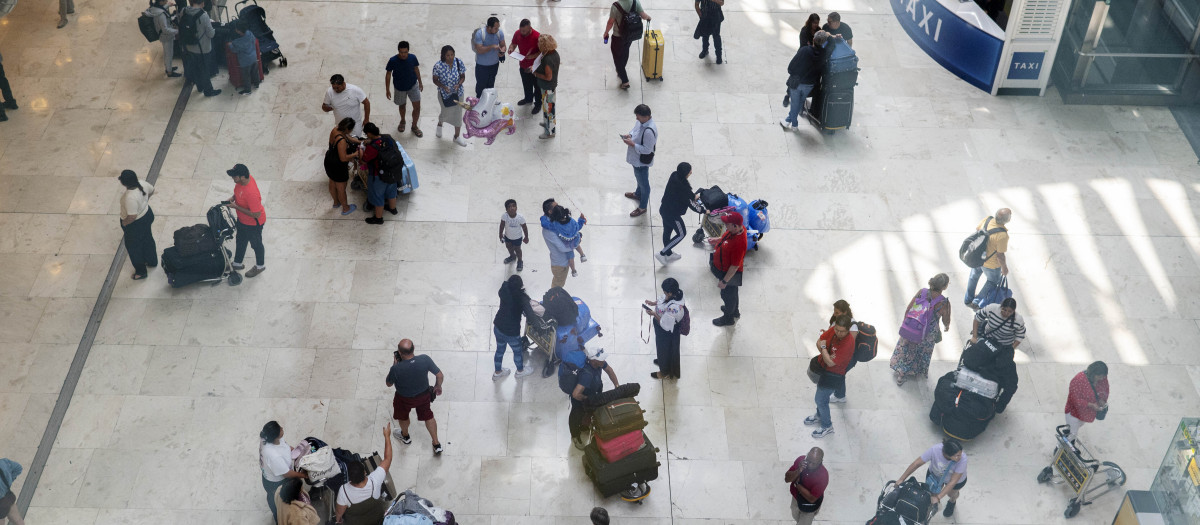 Varias personas con maletas en la terminal T4 del aeropuerto Adolfo Suárez Madrid-Barajas