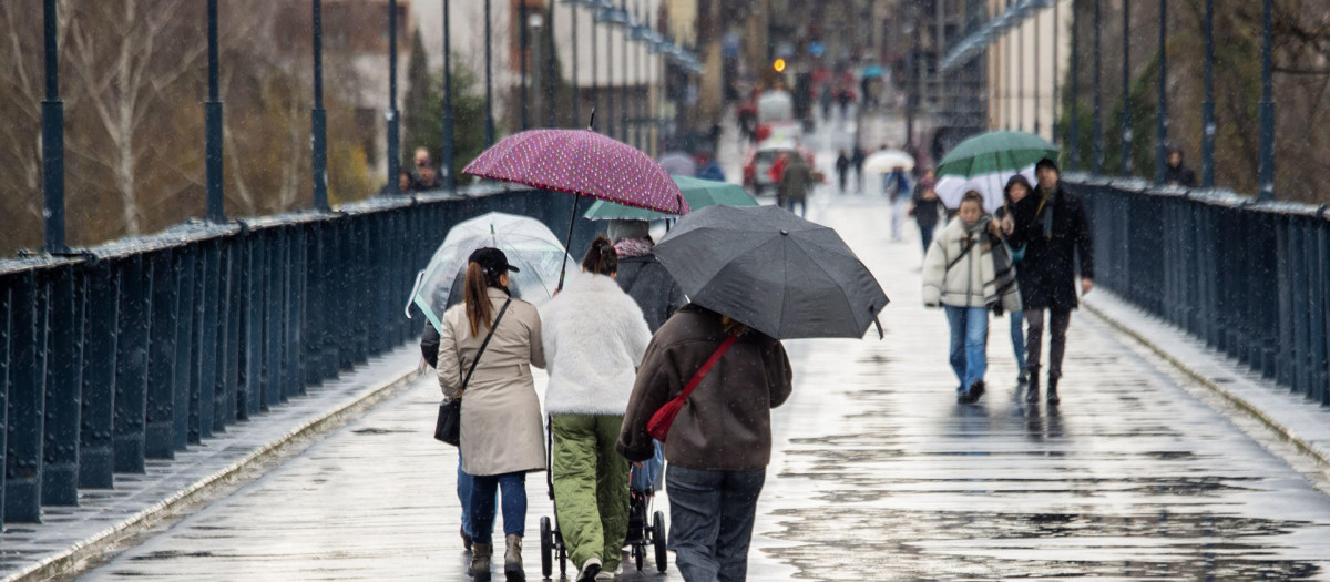 Varias personas se protegen de la lluvia en Logroño