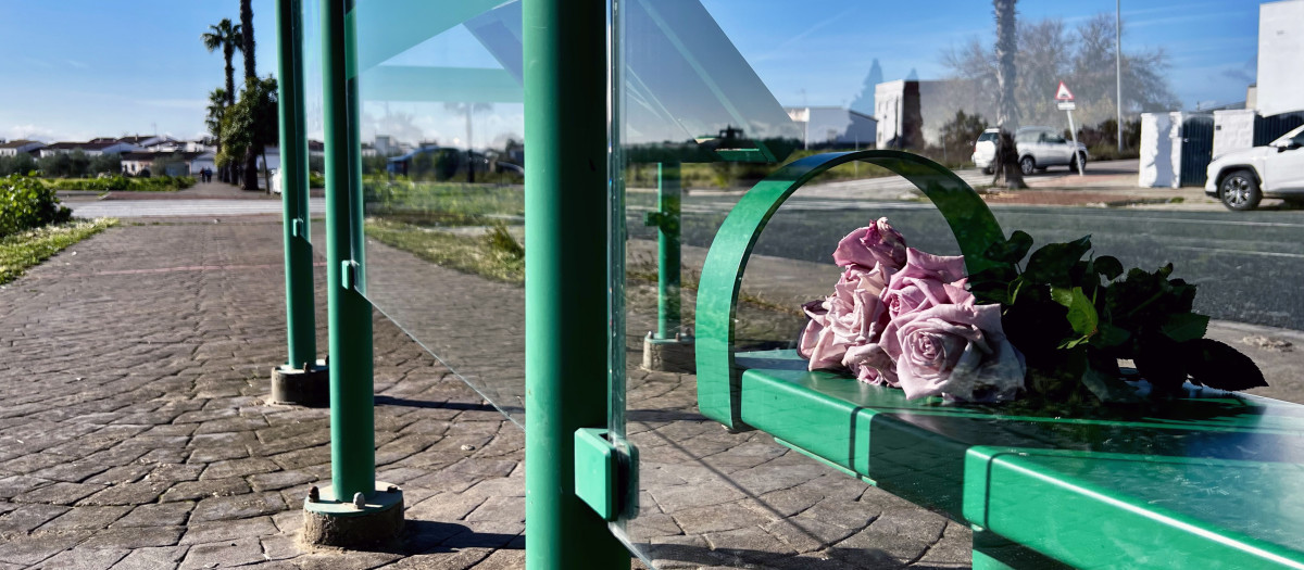 Un ramo de flores en una parada de autobús de Gerena (Sevilla), en el entorno donde ayer fue apuñalado mortalmente un menor de 17 años a la salida de su instituto