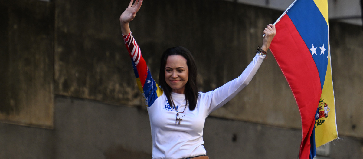 La líder opositora venezolana María Corina Machado ondea una bandera nacional durante una protesta convocada por la oposición en vísperas de la investidura presidencial, en Caracas el 9 de enero de 2025