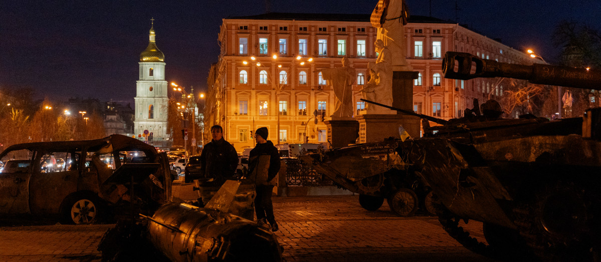 Varias personas caminan alrededor de una exposición al aire libre de vehículos militares rusos destruidos en la plaza Mykhailivska de Kiev