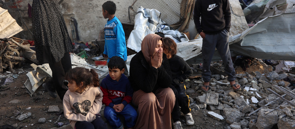 Una mujer observa la destrucción causada por un ataque israelí en la escuela Al-Farabi, en el centro de la ciudad de Gaza