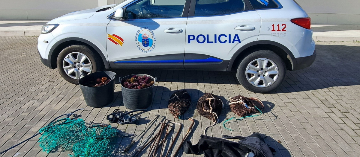 Agentes de la Unidad de Policía Nacional Adscrita de Galicia (UPA) de la jefatura de La Coruña, con el marisco intervenido