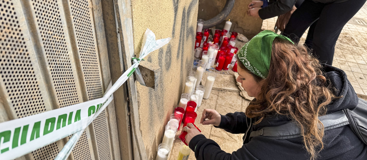 Vecinos de Benetúser improvisan un pequeño altar con velas a las puertas del garaje donde el pasado sábado falleció un operario que trabajaba en su limpieza