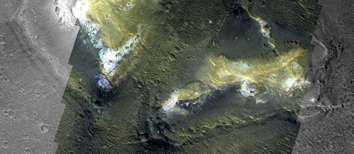 Dos montículos prominentes, que se elevan cientos de metros sobre las tierras bajas circundantes, muestran regiones brillantes ricas en minerales arcillosos