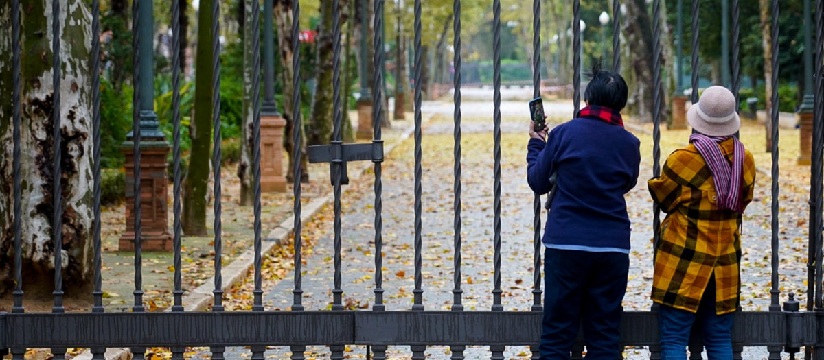 Turistas en las rejas cerradas del Parque de María Luisa, en una foto de archivo