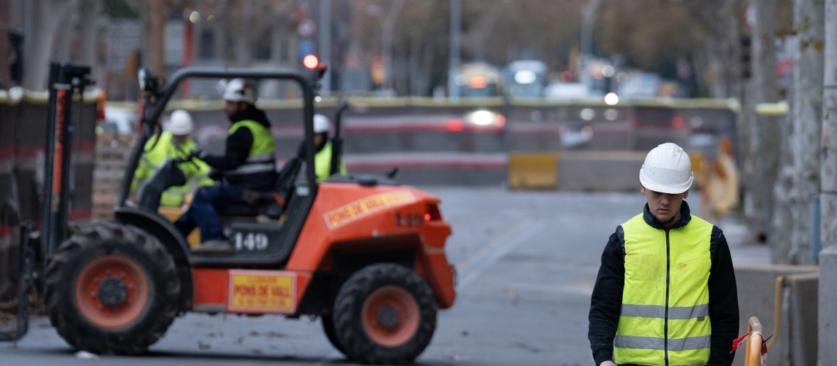 Varios operarios trabajan en un tramo de la calle Urgell, en Barcelona