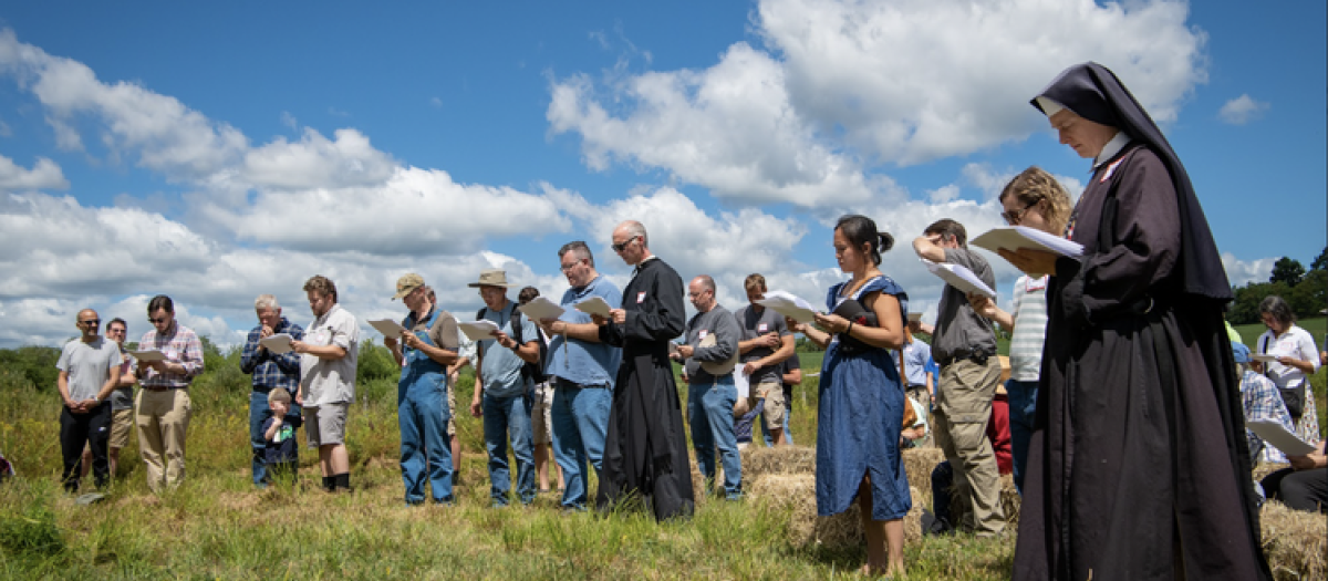 Un grupo de católicos reza en el campo tras la jornada de trabajo