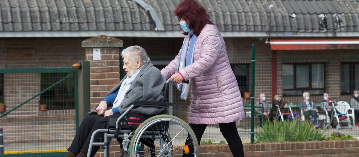 Una mujer pasea a una anciana en silla de ruedas, en las inmediaciones de la residencia geriátrica de As Gándaras
