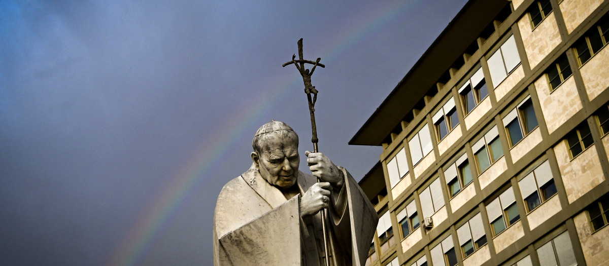 A rainbow appears above a statue of Pope John Paul II outside the Gemelli hospital where Pope Francis is hospitalised for tests and treatment for bronchitis in Rome, on February 18, 2025. The Vatican on February 18, 2025 cancelled two of Pope Francis's events at the weekend as the 88-year-old continues to receive hospital treatment for bronchitis. (Photo by Tiziana FABI / AFP)