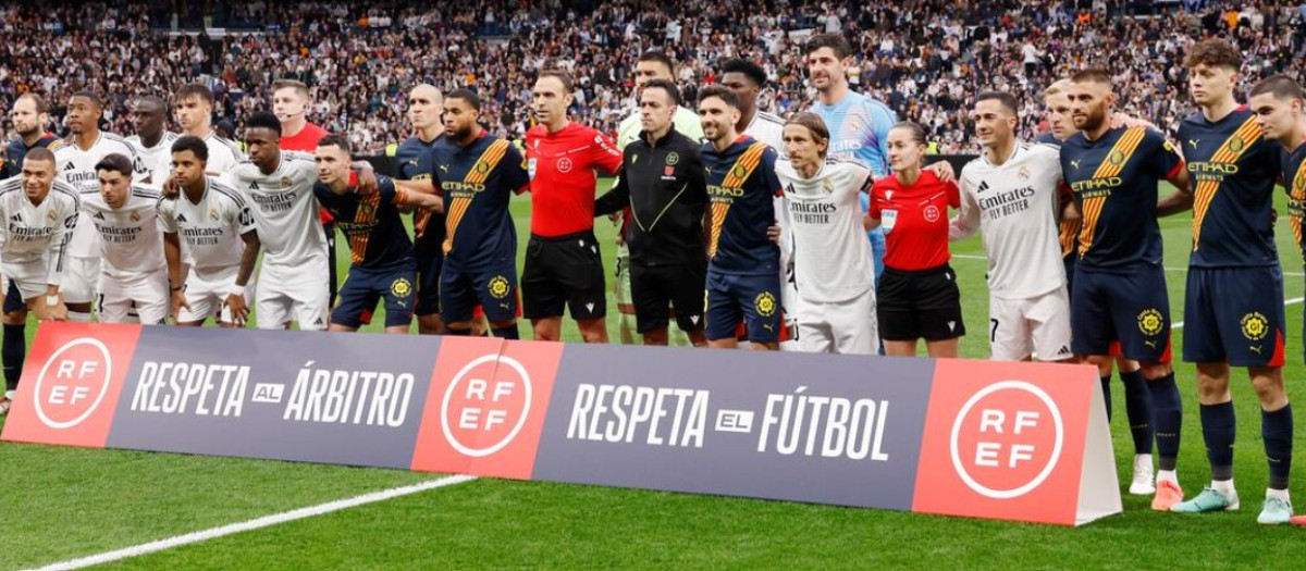 Los jugadores del Real Madrid y el Girona posan con la pancarta de apoyo a los árbitros