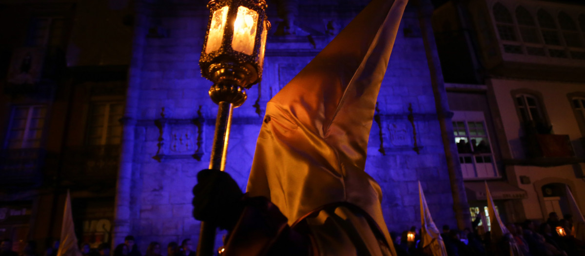 Viveiro, Lugo. Semana Santa de Viveiro, declarada de interés turístico internacional. Procesión del Prendimiento, que consta de cinco pasos. En la imagen, un nazareno pasa frente a la Puerta de Carlos V, en la noche del jueves 6 de abril