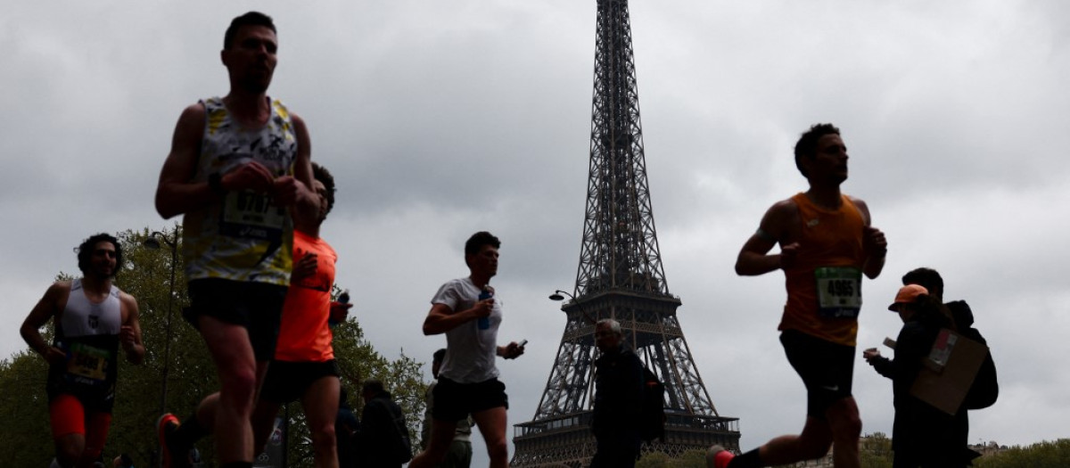 Corredores pasan junto a la Torre Eiffel en París