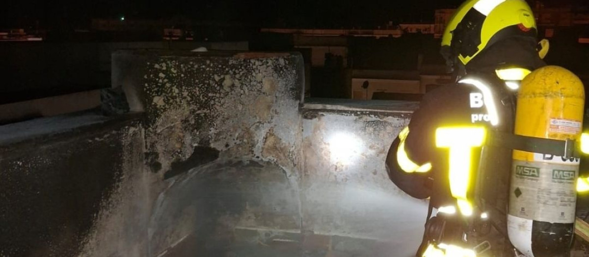 Un bombero sofoca el incendio en una terraza de una vivienda de Cádiz.