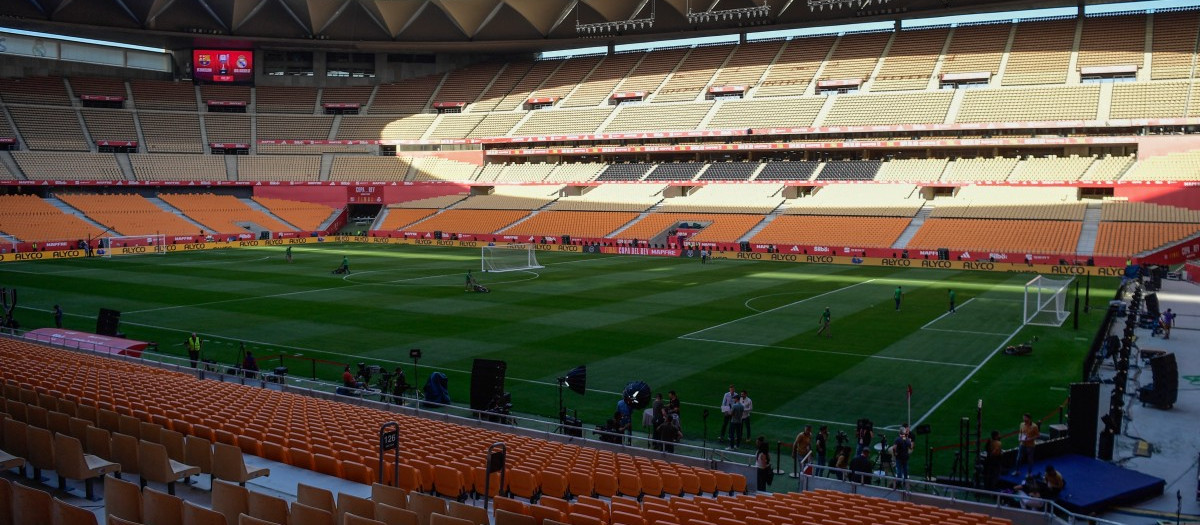 El personal de mantenimiento corta el césped después de que el Real Madrid no asistiera a una sesión de entrenamiento en el estadio de La Cartuja