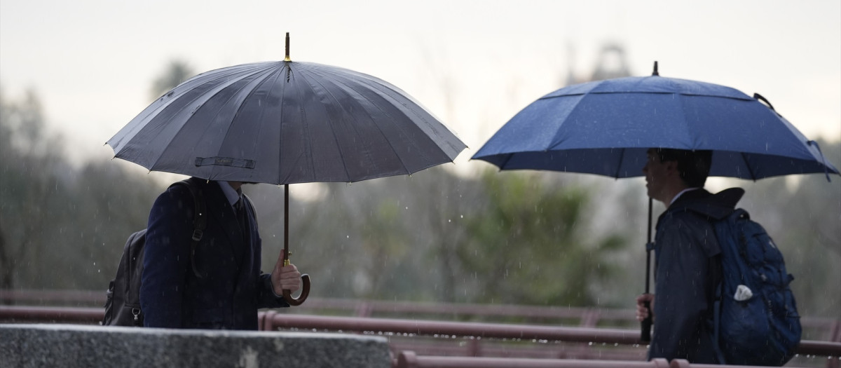 Varias personas se protegen de la lluvia con un paraguas