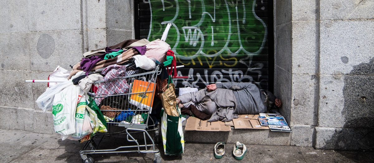 Una persona sintecho duerme en una calle de Madrid