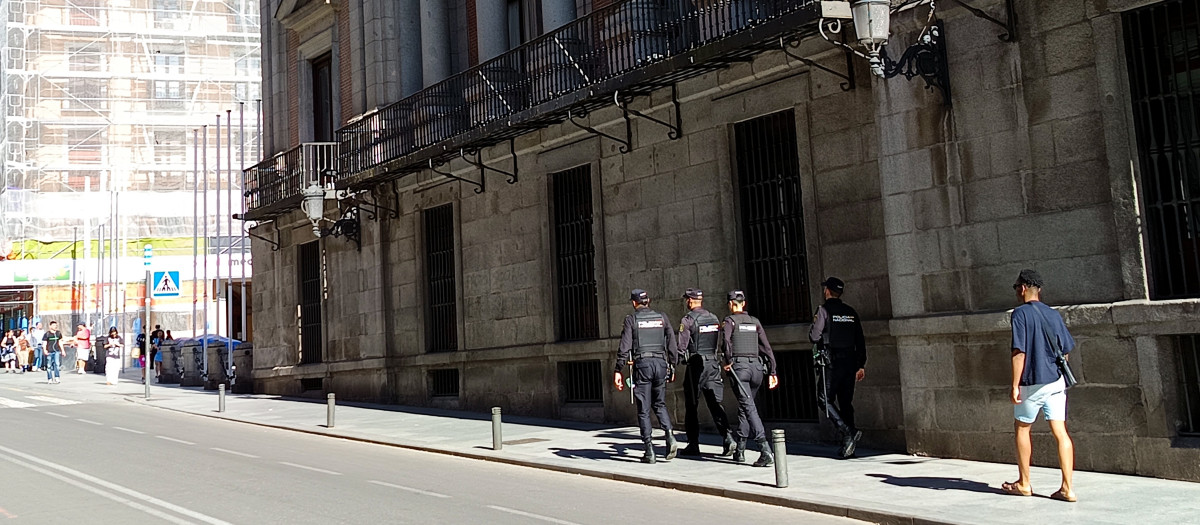 Cuatro agentes de la Policía Nacional patrullan por la calle Mayor de Madrid