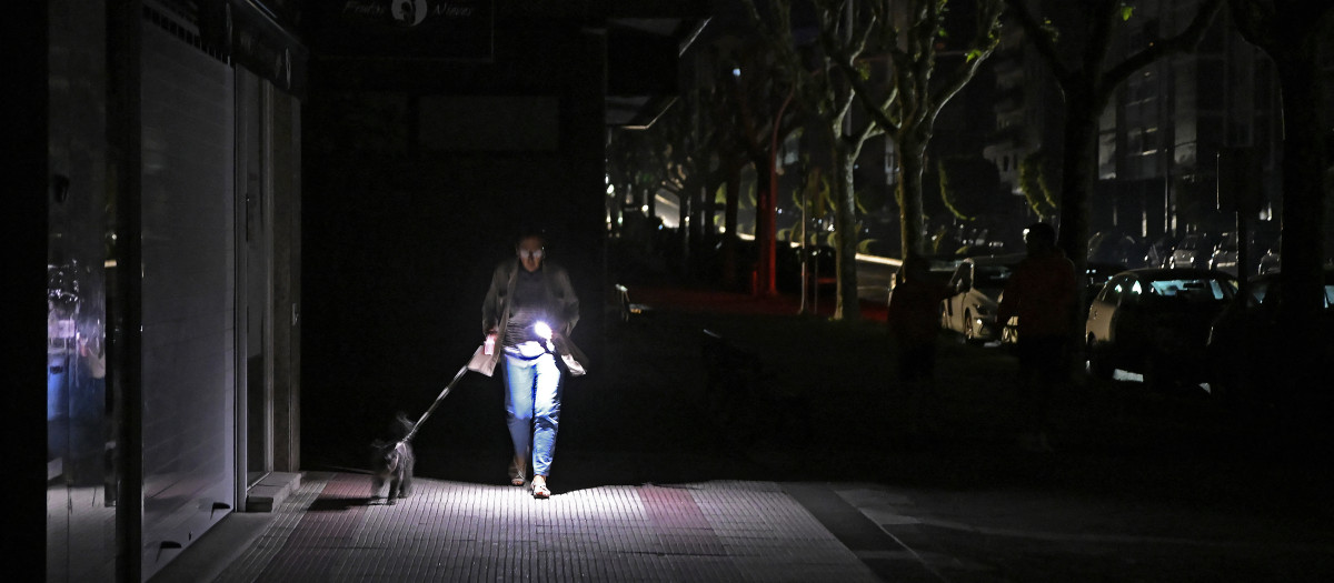 Una mujer pasea a su perro el día del apagón en Vigo