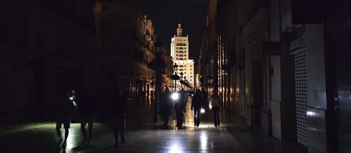 Vista de la céntrica calle Larios de Málaga, una de las más reconocidas de España, a oscuras durante la noche del lunes durante el apagón eléctrico