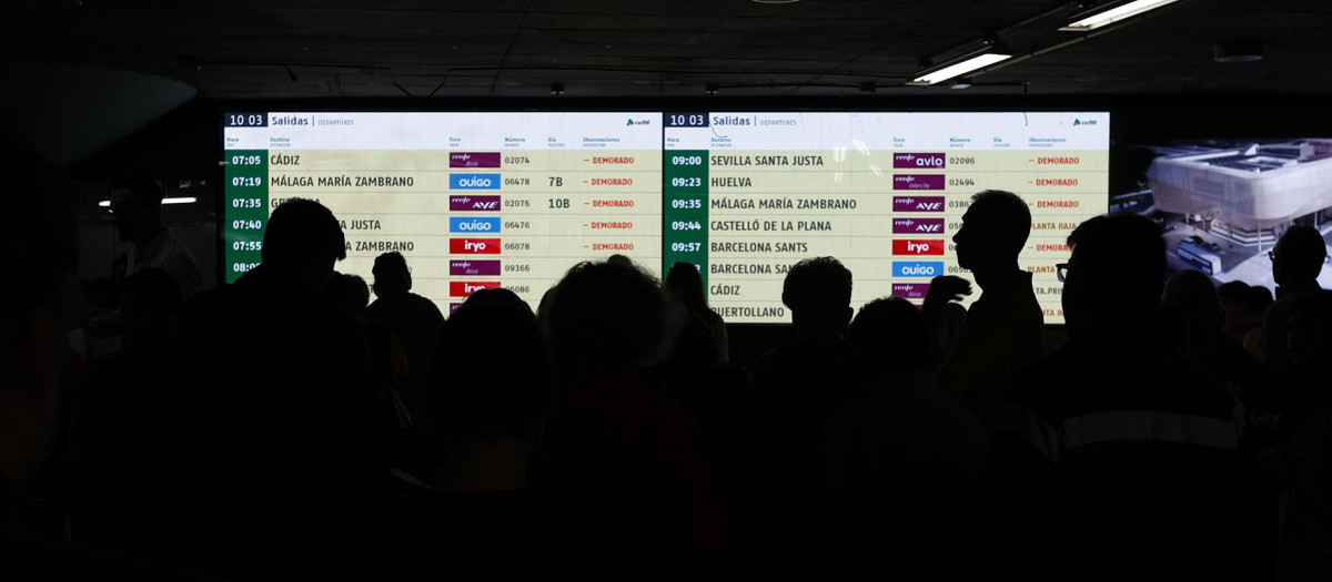 Viajeros afectados observan los paneles en Atocha