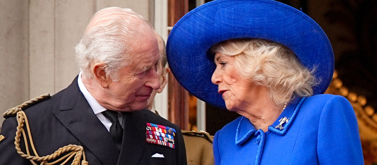 Britain's King Charles III and Britain's Queen Camilla speak, on the balcony of Buckingham Palace after attending the armed forces procession on May 5, 2025 to celebrate the 80th anniversary of VE Day also known as Victory in Europe Day, marking the end of the Second World War in Europe. (Photo by Aaron Chown / POOL / AFP)