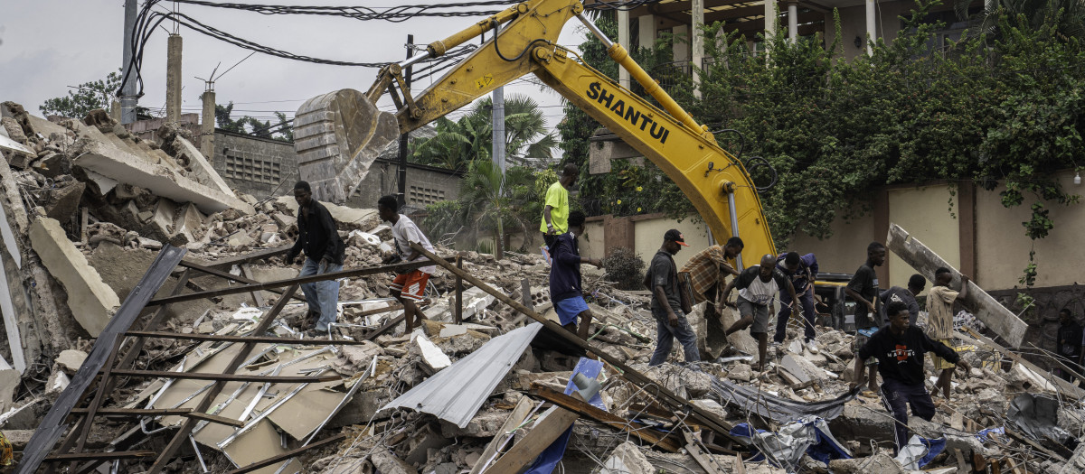 Los residentes recogen escombros de las casas que están siendo demolidas en Kinshasa, República Democrática del Congo, el 8 de mayo de 2025, por las inundaciones