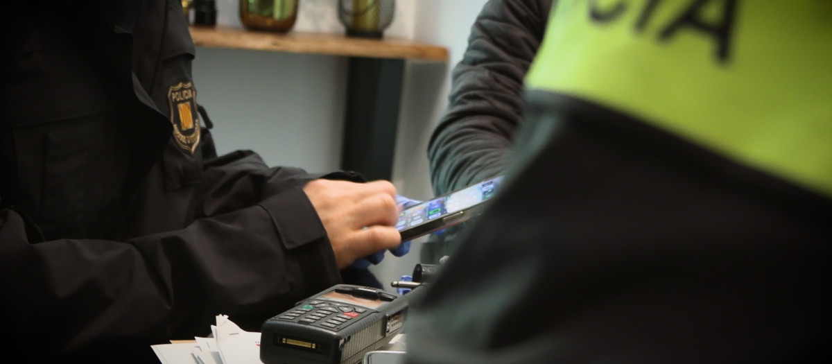 Agentes de los Mossos de Esquadra revisan los dispositivos de los tenidos por formar parte, presuntamente de una red de pederastas