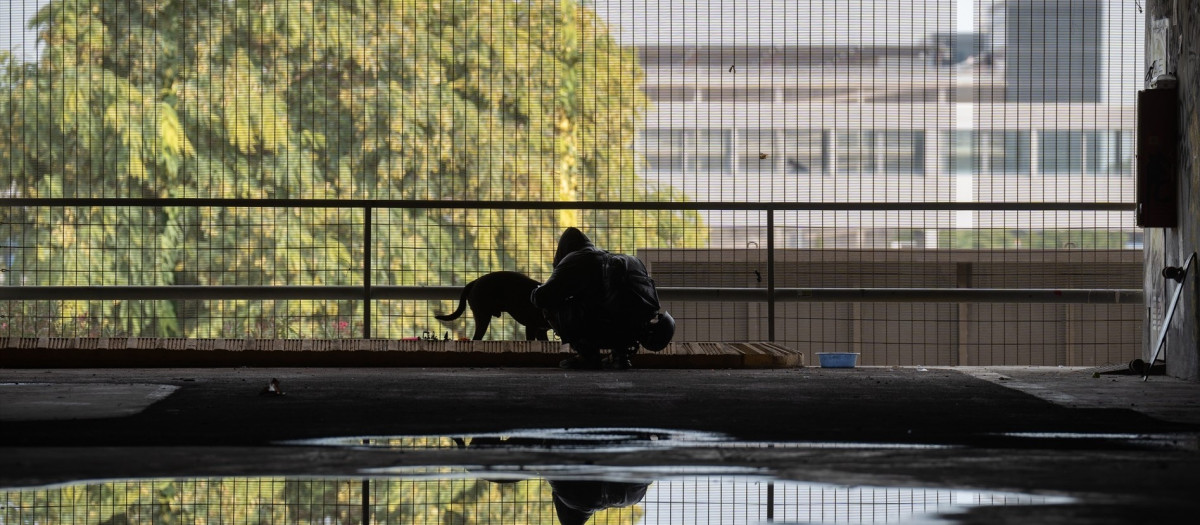 Una persona con un perro en el parking abandonado de la T2 del aeropuerto del Prat, en 2022