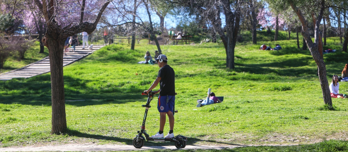 Un hombre montando en patinete en la Casa de Campo