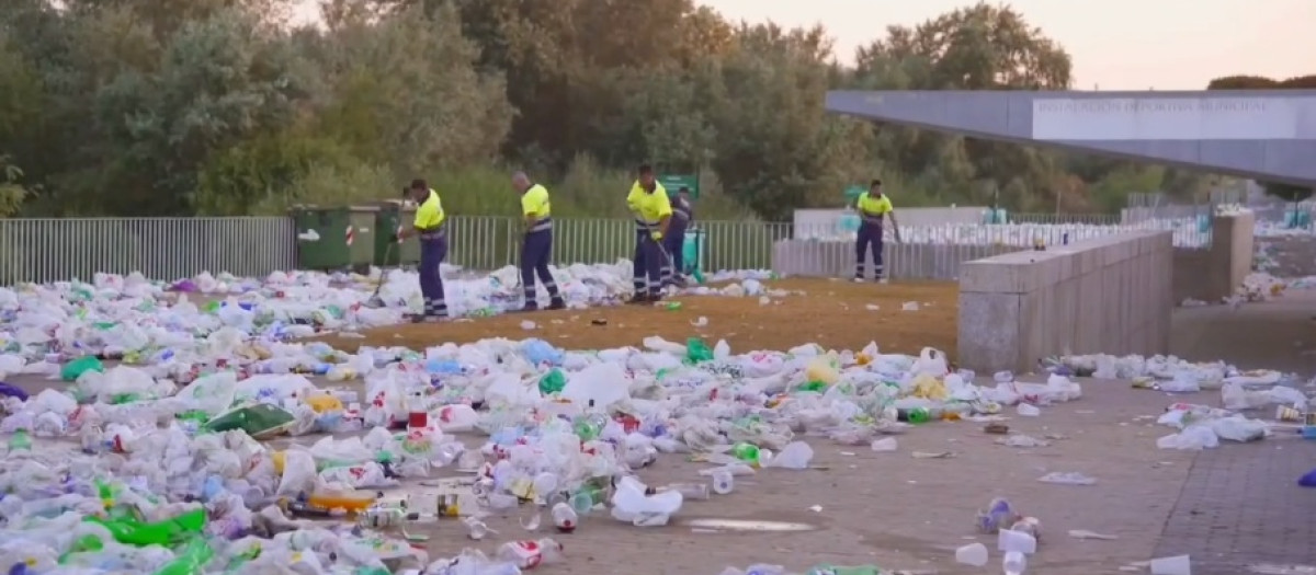 Operarios de Sadeco limpian la basura dejada por el botellón en el Balcón del Guadalquivir