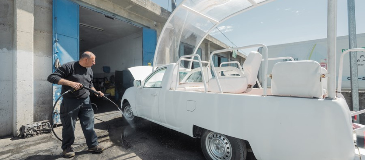 Un operario de Cáritas Jerusalén limpia a fondo el papamóvil-ambulancia