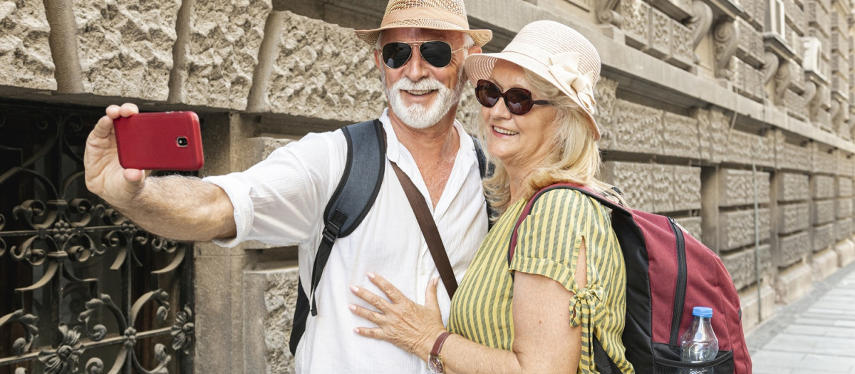Una pareja senior se hace un selfi durante un viaje.
