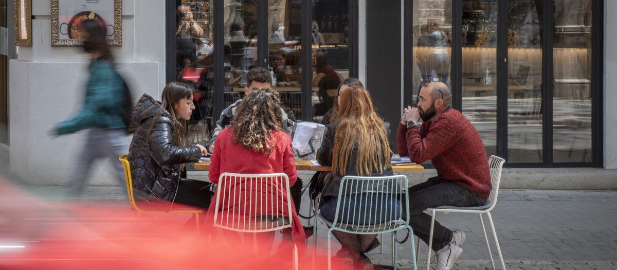 Imagen de seis personas sentadas en una terraza en Valencia.