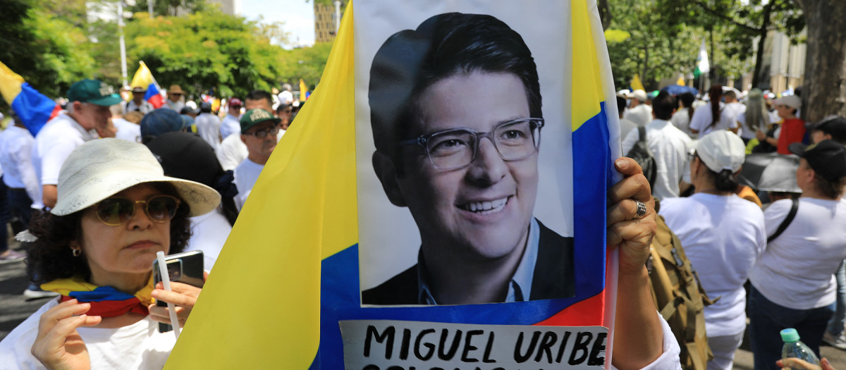 Una foto del senador Miguel Uribe Turbay sobre la bandera colombiana durante la Marcha del silencio