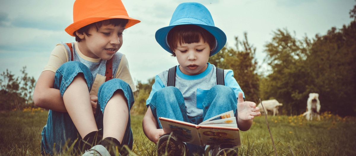 Dos niños leyendo y comentando un libro