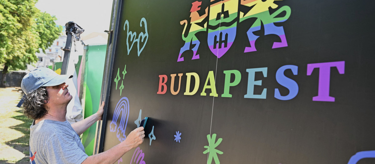 Un trabajador prepara un cartel arcoíris con el logotipo del ayuntamiento de Budapest en el centro de la capital el 27 de junio de 2025