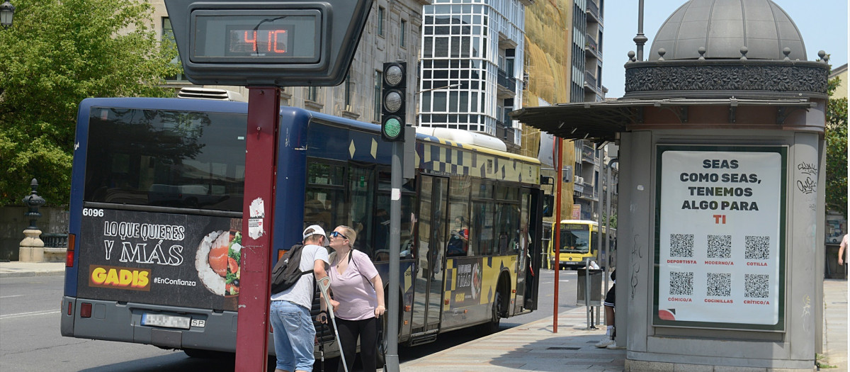 Dos personas se saludan al lado de un termómetro en la calle que marca 41 grados, a 12 de julio de 2022, en Orense, Galicia (España)
