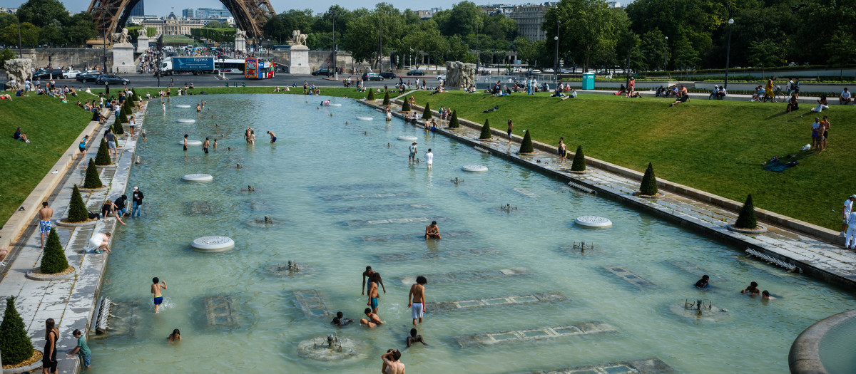 La gente se refresca en la Fuente del Trocadero, frente a la Torre Eiffel en París