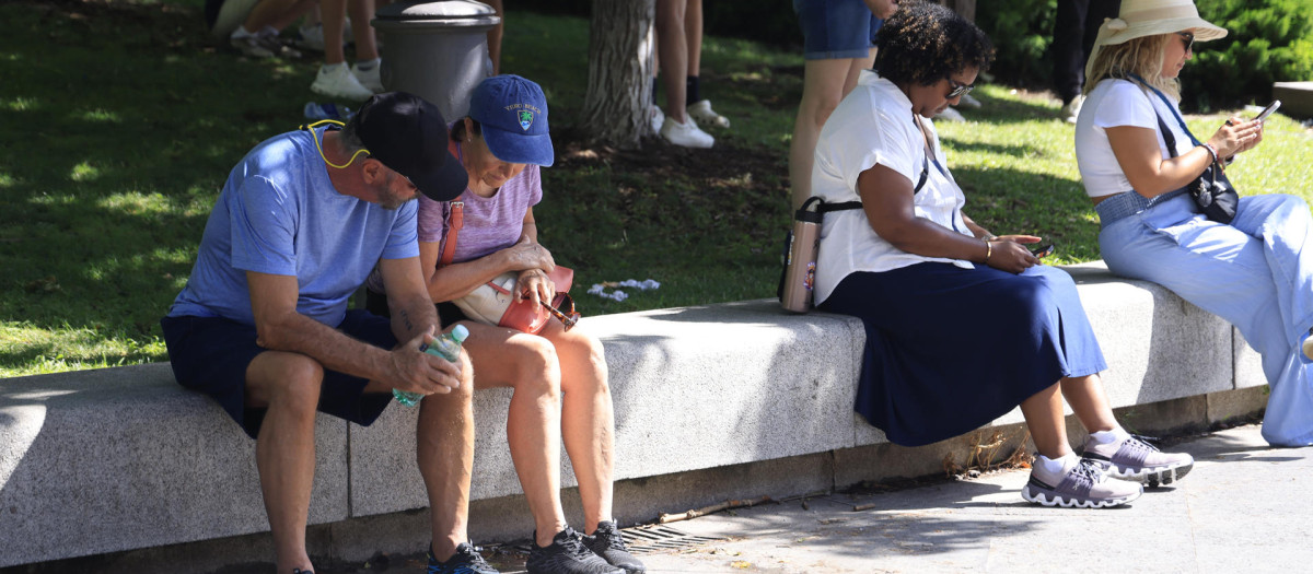 Varias personas protegen del calor, este viernes en Madrid