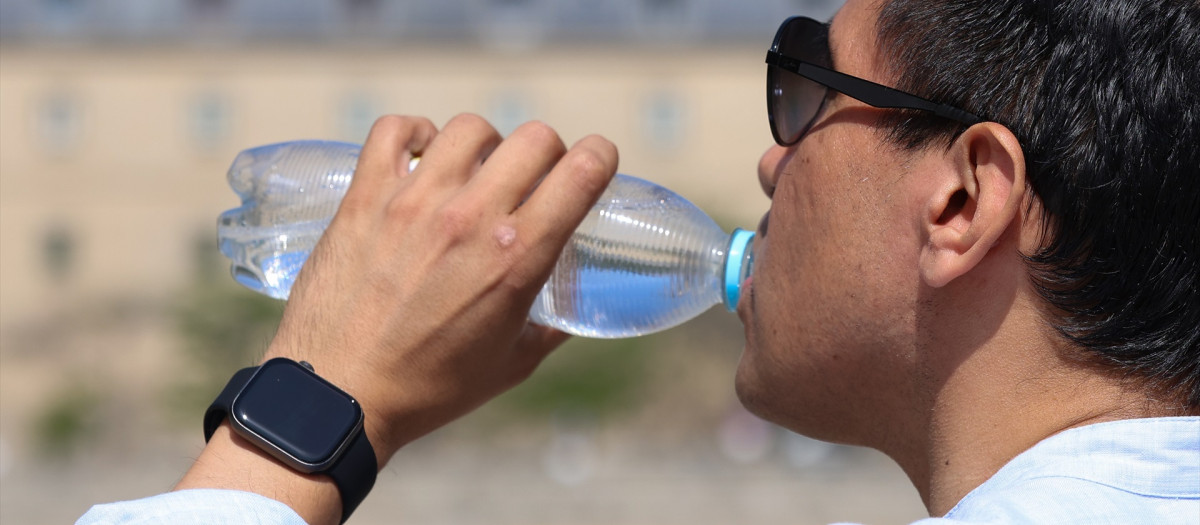 Un hombre bebe agua durante la ola de calor