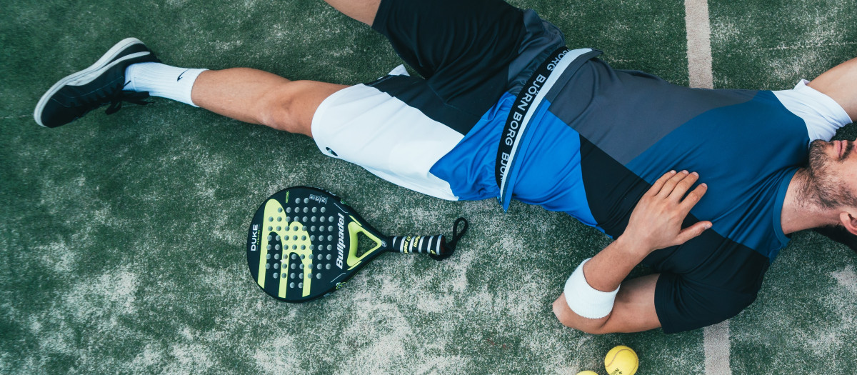 Un joven cansado después de jugar al tenis