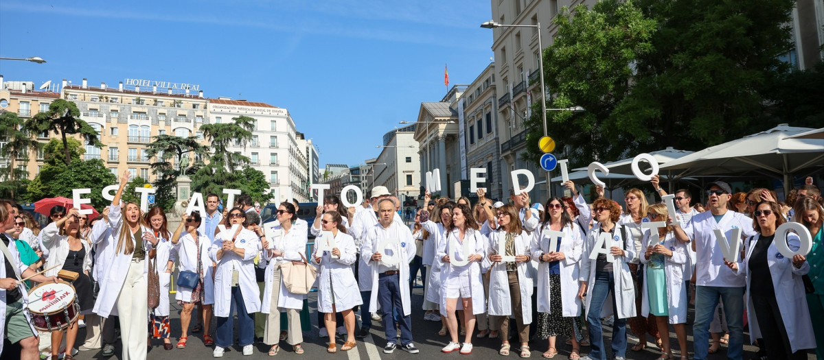Un grupo de médicos con batas blancas se manifiestan