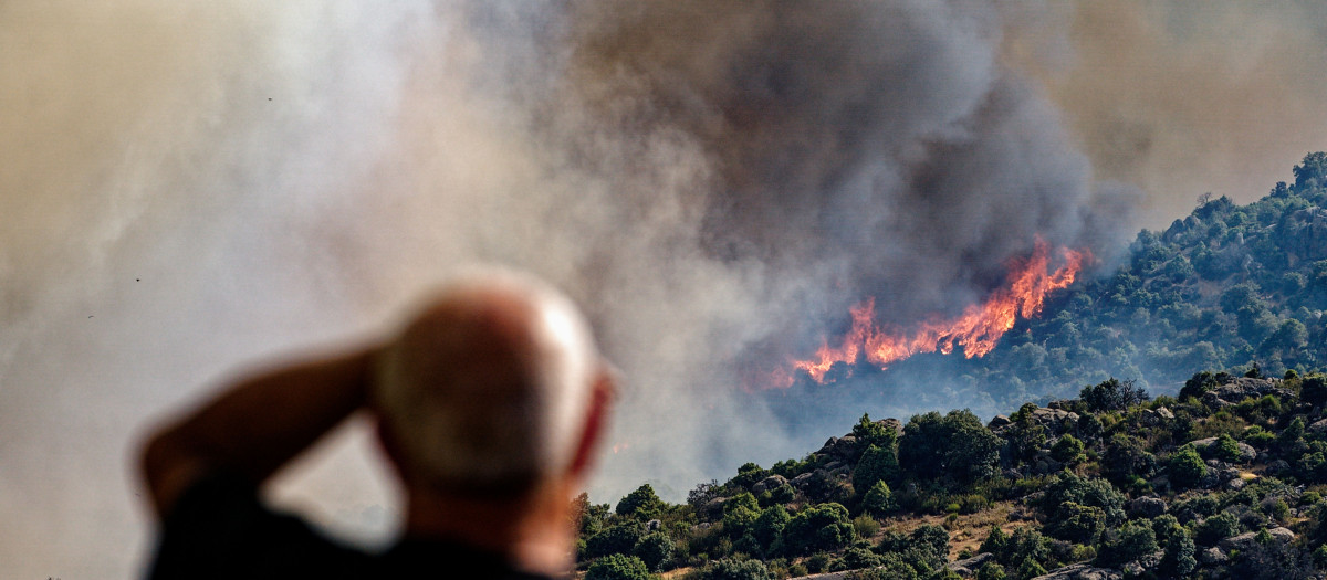 Un hombre contempla el incendio forestal declarado en Navaluenga (Ávila)