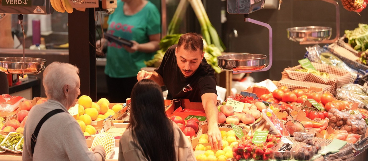 Un frutero atiende una parada en el Mercado de la Estrella de Barcelona