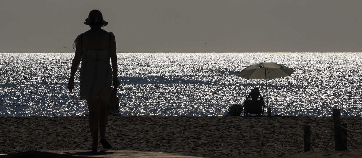 Imagen tomada este lunes de dos personas en la playa de El Saler, en Valencia