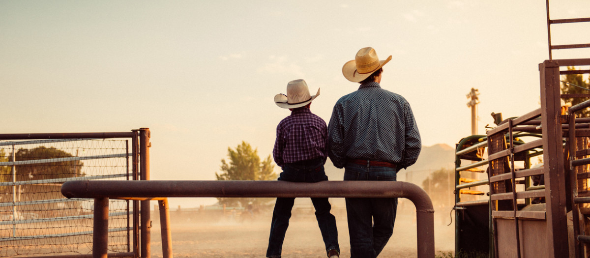 Padre e hijo en un rancho vaquero.